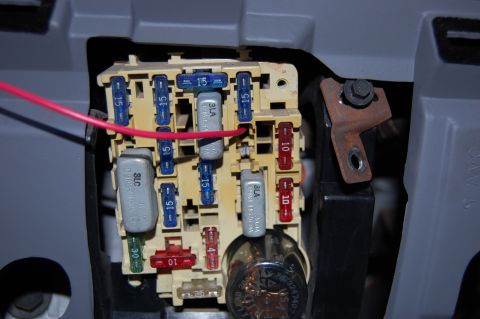 1994 Ford Bronco - This image shows a vehicle's interior fuse box with various fuses and a red wire attached.