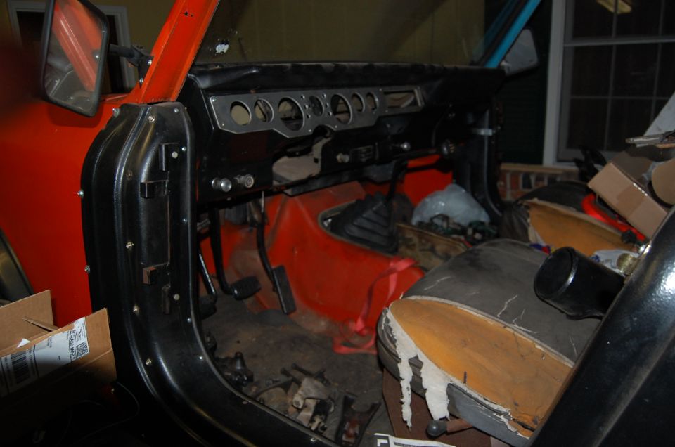 Interior view of a Jeep showing dashboard, pedals, and seats. Supermotors.net logo visible