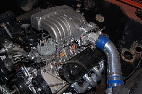 1994 Ford Bronco - The engine bay shows a V8 engine with custom modifications, including a prominent intake manifold and exhaust headers.
