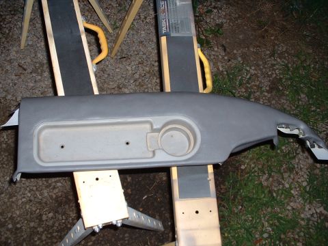 1994 GMC Suburban - Dashboard trim piece with cup holder, likely from an older GM vehicle, is shown on sawhorses.