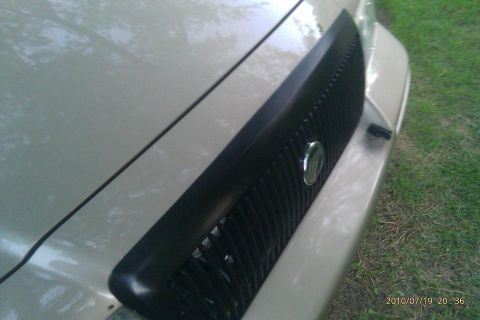 2000 Mercury Grand Marquis - Close-up of the black grille and hood of a Mercury Grand Marquis, with a badge visible in the center.
