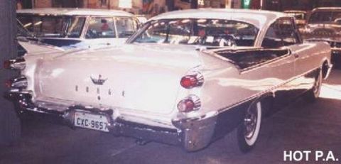 1991 Ford Crown Victoria - Rear view of a white 1957 Dodge showing its distinctive fins and chrome bumper.