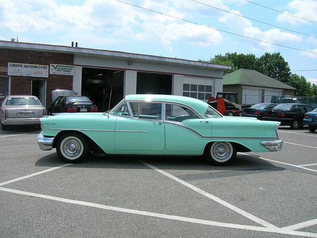 Mint green 1956 Oldsmobile 88 two-door sedan parked in front of Linden Automotive