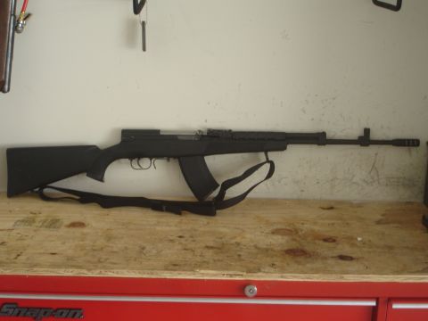1989 Ford Bronco - Black SKS rifle with a detachable magazine and sling, displayed on a workbench.