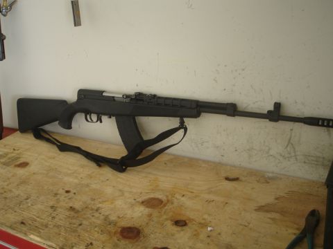 1989 Ford Bronco - A black SKS rifle is displayed on a wooden table against a white wall.