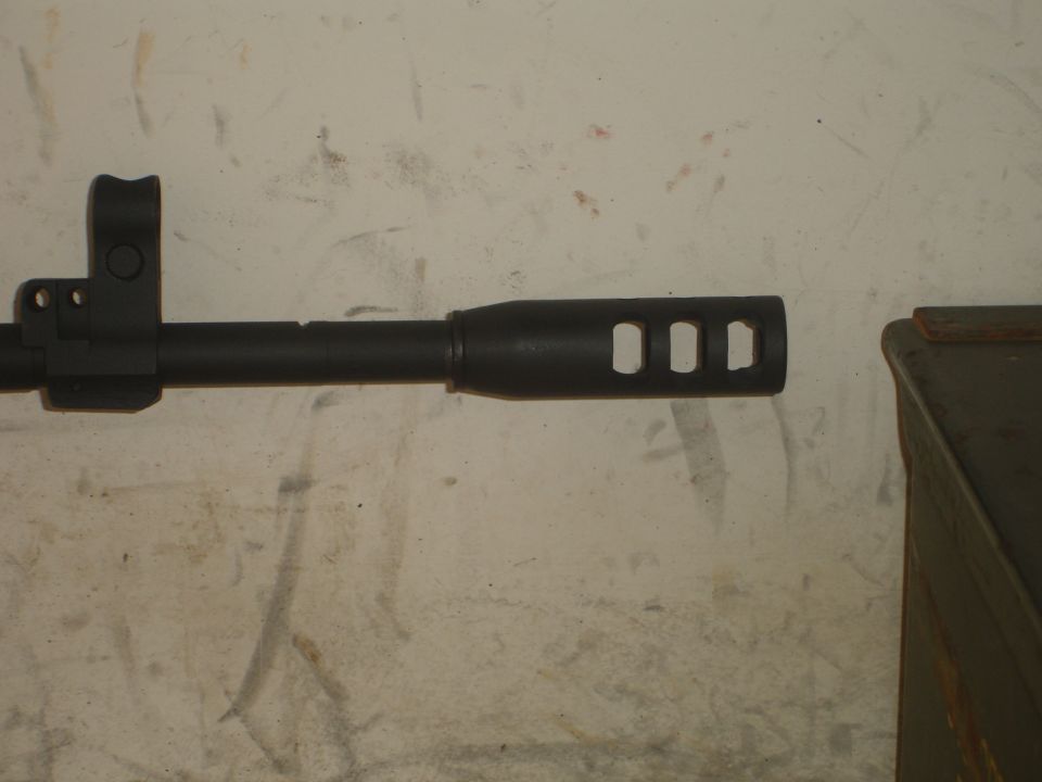 Close-up of a gun barrel with a muzzle brake three rectangular ports
