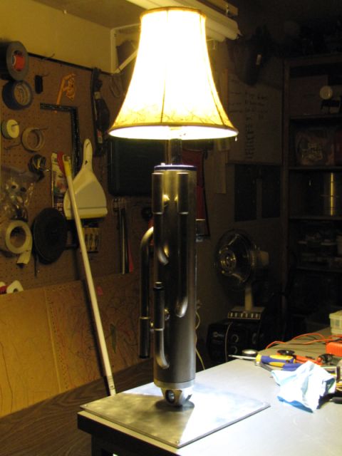 1984 Ford Bronco - A table lamp with a unique metal base sits on a workbench, surrounded by tools and workshop items.