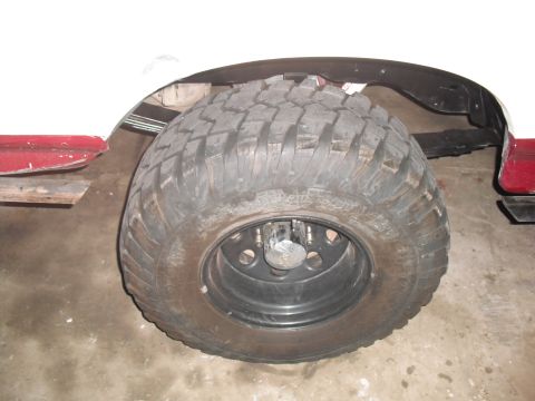 1991 Ford Bronco - Close-up of a vehicle's wheel and tire assembly, showing the tread pattern and suspension components.