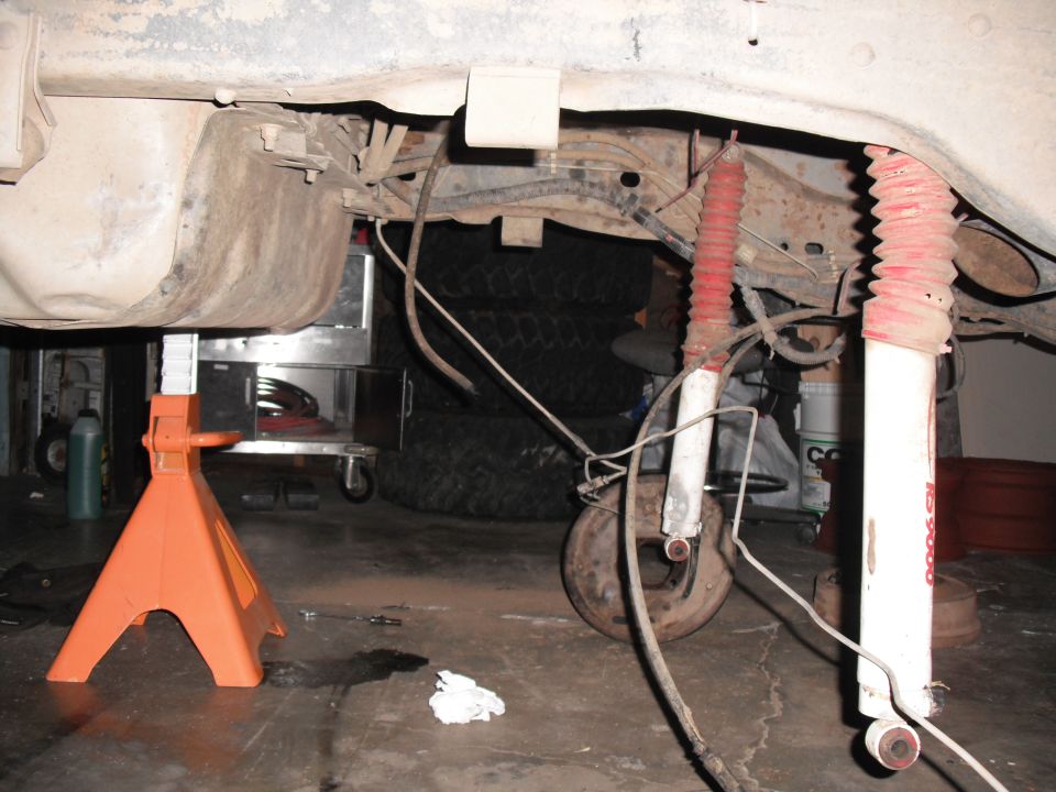 Rear suspension components including shocks and fuel tank, vehicle on jack stands