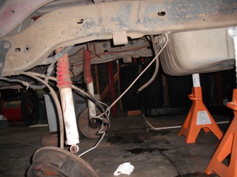 1991 Ford Bronco - The rear axle, fuel tank, and suspension components are visible in this underside shot.