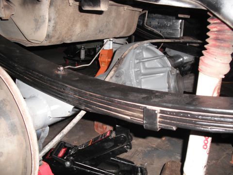 1991 Ford Bronco - The rear suspension of a 1991 Ford Bronco is visible, with the axle and leaf springs supported by jacks.