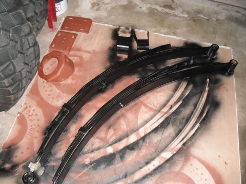 1991 Ford Bronco - Leaf springs and suspension parts laid out for painting.