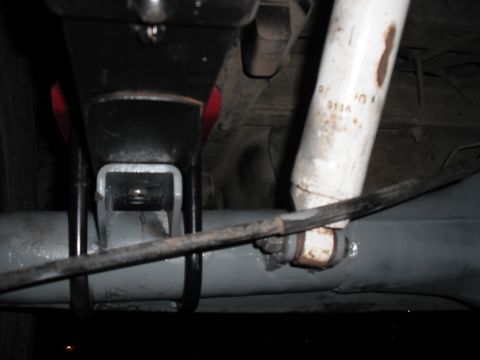 1991 Ford Bronco - Underside view shows a white shock absorber with visible markings and a metal bracket attached to the axle.