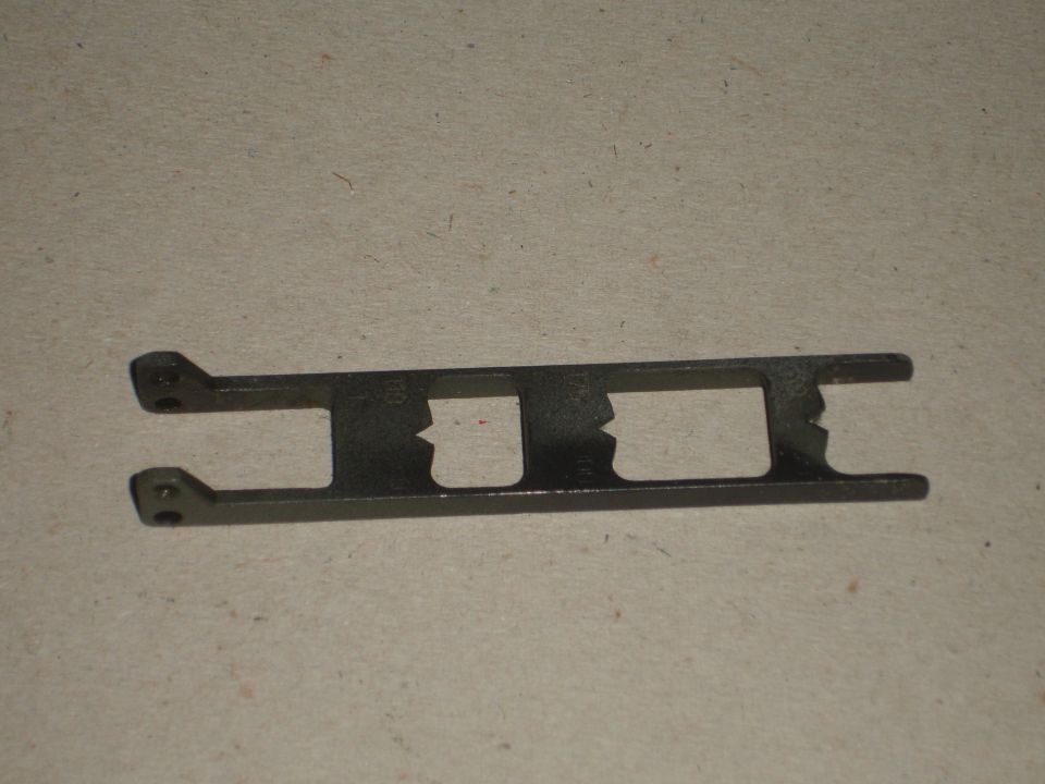 Metal bracket with two rectangular cutouts and mounting holes
