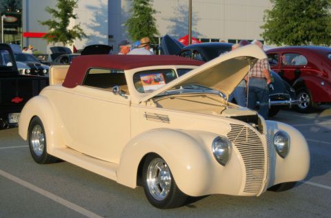 1980 Ford Mustang - A vintage convertible is displayed with its hood open at an outdoor car show event.