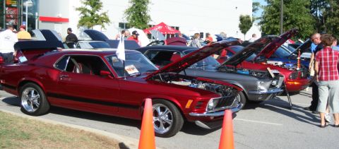 1980 Ford Mustang - Several classic cars are displayed with their hoods open at an outdoor event.