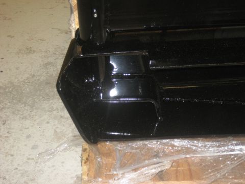 1978 Ford Bronco - A black bumper, possibly for an off-road vehicle, rests on a wooden pallet.
