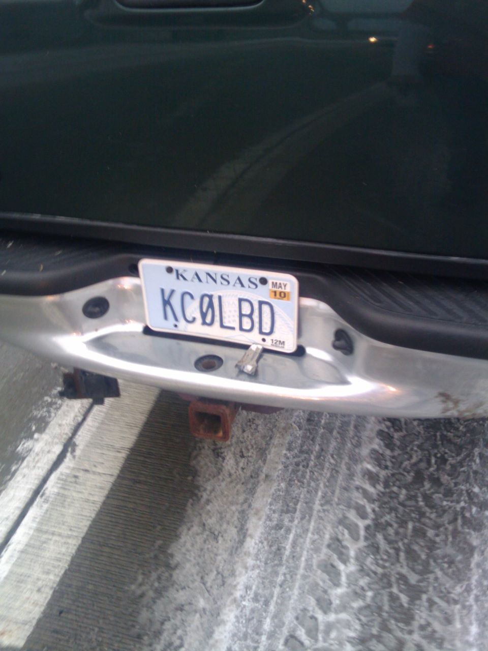 Rear bumper of a dark colored truck with a Kansas license plate that reads KCØLBD