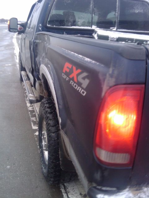 2005 Ford F-250 - Rear view of a dark colored 2005 Ford F-250 pickup truck in snowy conditions.