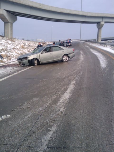 2005 Ford F-250 - A damaged silver sedan sits on the side of a highway with other vehicles and emergency personnel present.