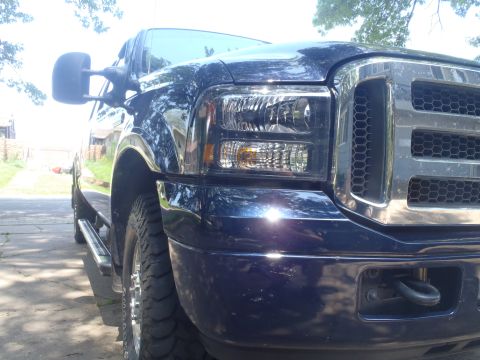 2005 Ford F-250 - Front corner view of a dark blue 2005 Ford F-250 truck with a chrome grille and tow hook.