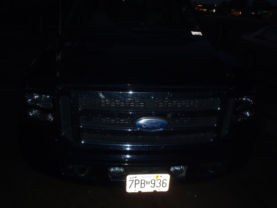 Front view of a dark-colored 2005 Ford F-250 truck with a chrome grille and headlights