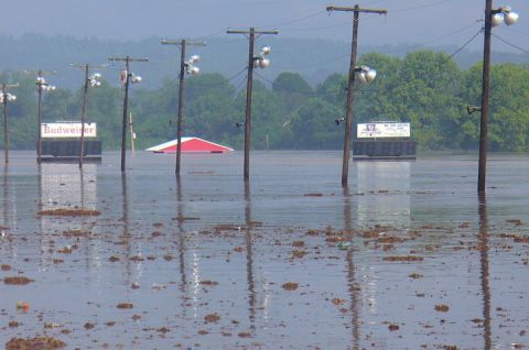 2007 Ford Mustang - Flooded landscape with utility poles and signs, a building is partially submerged in the water.