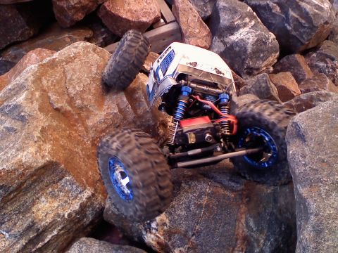 1996 Ford Bronco - A remote control rock crawler is shown maneuvering over a challenging rocky obstacle course.