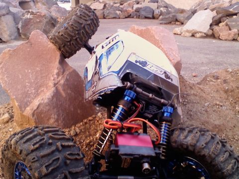 1996 Ford Bronco - This remote control rock crawler is navigating a rocky terrain, with one of its wheels caught on a large stone.