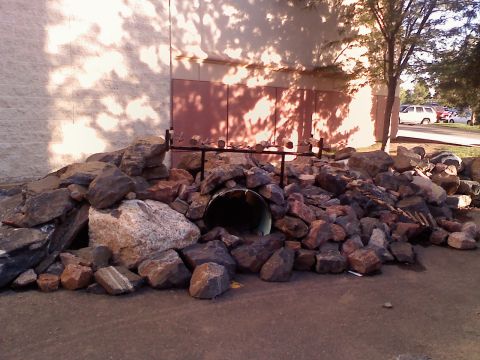 1996 Ford Bronco - Rock obstacle course with tunnel in front of building.