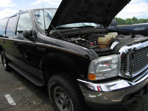 2001 Ford Crown Victoria - Black SUV with hood open, engine compartment exposed. The vehicle is seen from a three-quarter front angle.