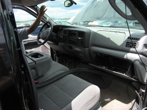 2001 Ford Crown Victoria - Interior of a 2003 Ford F-250 Super Duty truck with the hood open, showing the dashboard and seats.