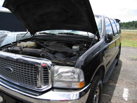 2001 Ford Crown Victoria - Front view of a black Ford Excursion with its hood open, revealing the engine compartment.