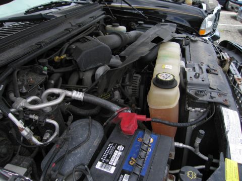 2001 Ford Crown Victoria - Close-up view of a Ford truck's engine compartment, highlighting various mechanical parts and the battery.