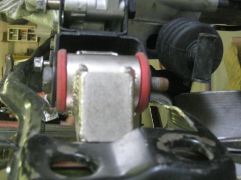 1994 Ford Probe - A close-up view of a vehicle's suspension system, focusing on a metal component with red bushings.