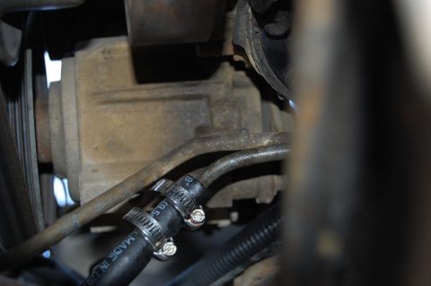 1994 Ford Bronco - Close-up view of transmission cooler lines and a hose clamp on a vehicle part.