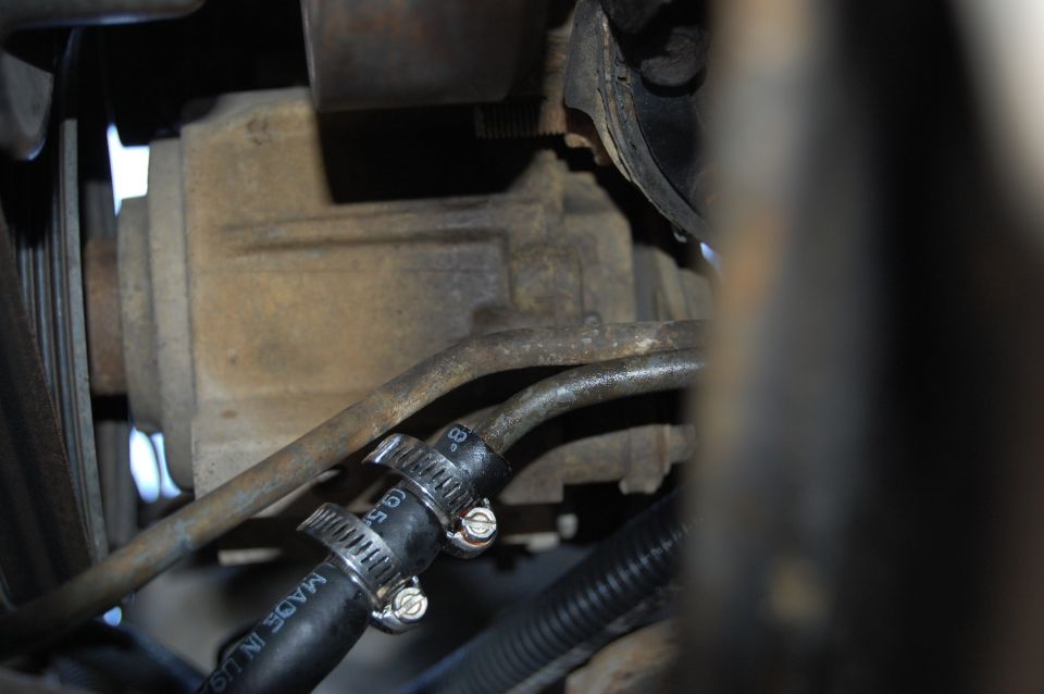Transmission cooler lines with hose clamps and black hose, some dirt and grime