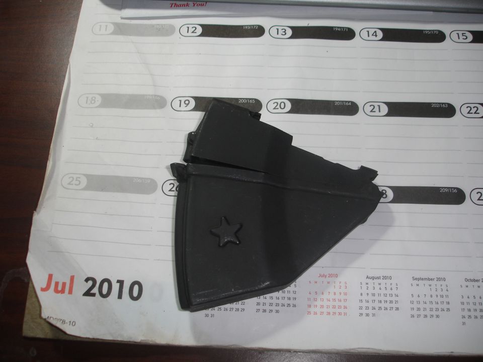 black plastic part with a star emblem on a calendar page