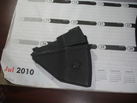 1989 Ford Bronco - A black plastic part with a star emblem is shown on a calendar from July 2010.