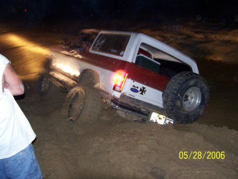 1986 Ford Bronco - This 1980s Ford Bronco is stuck deep in the mud, with its tires partially submerged.
