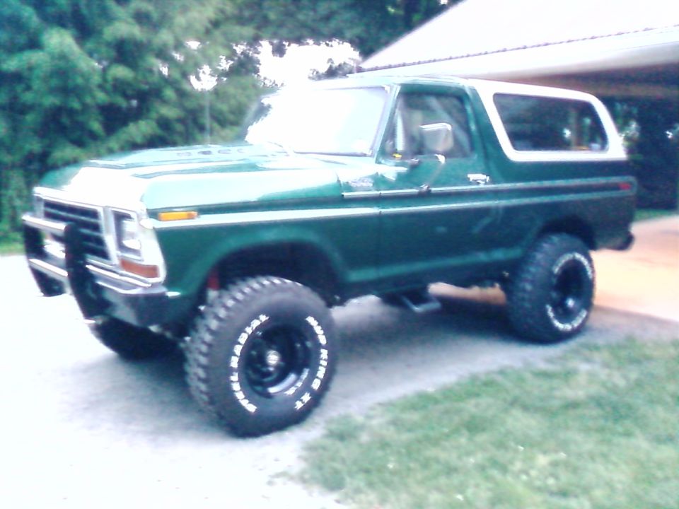 Green 1979 Ford Bronco with white top and off-road tires