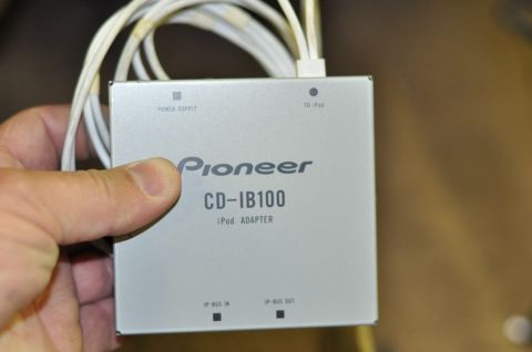 1996 Ford Bronco - A Pioneer CD-IB100 iPod adapter is held in a hand, showing its model number and connection ports.