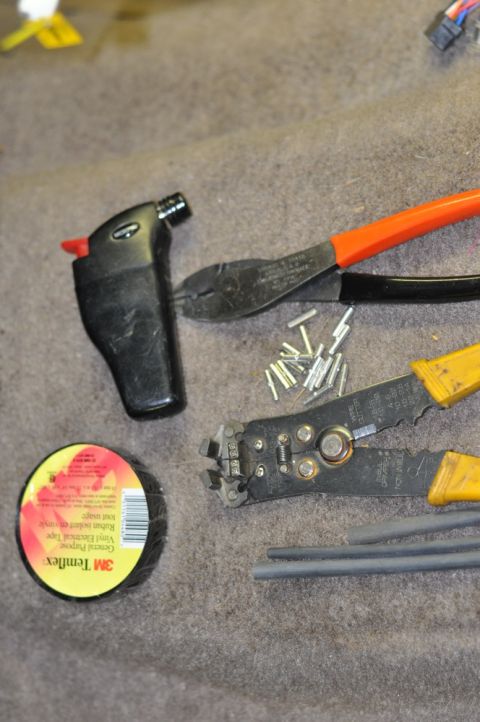1996 Ford Bronco - Tools and supplies for electrical work are laid out on a textured surface, possibly a vehicle's interior carpet.