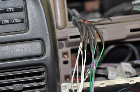 1996 Ford Bronco - Close-up of exposed wiring and control buttons inside a vehicle's dashboard.