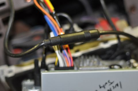 1996 Ford Bronco - A close-up view shows a black connector attached to a bundle of colorful wires, part of a vehicle's interior wiring.