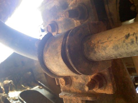 1990 Ford Bronco - This image shows heavily rusted suspension parts, including bolts and a pipe, with visible text from Supermotors.net.