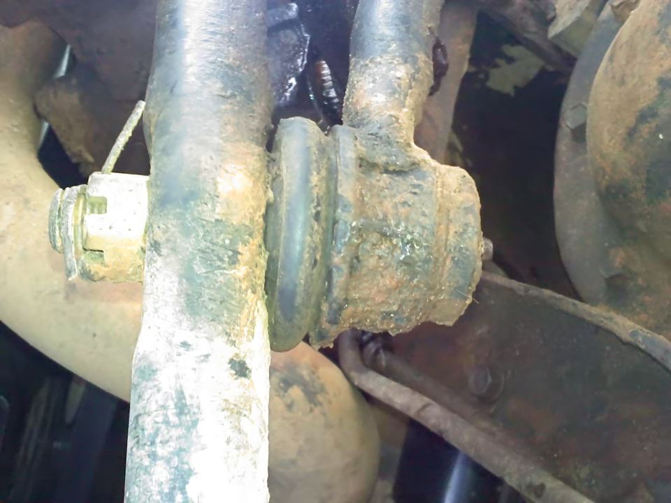 close-up of rusty suspension parts with a rubber bushing