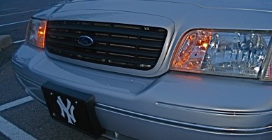 2000 Ford Crown Victoria - Front view of a silver 2000 Ford Crown Victoria, showing the grille, headlights, and a New York Yankees license plate frame.