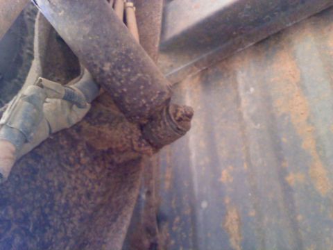1990 Ford Bronco - Close-up view of a corroded vehicle suspension component, showing signs of wear and tear.