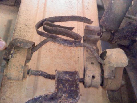 1990 Ford Bronco - Close-up view of heavily corroded metal suspension components, showing significant wear and tear.
